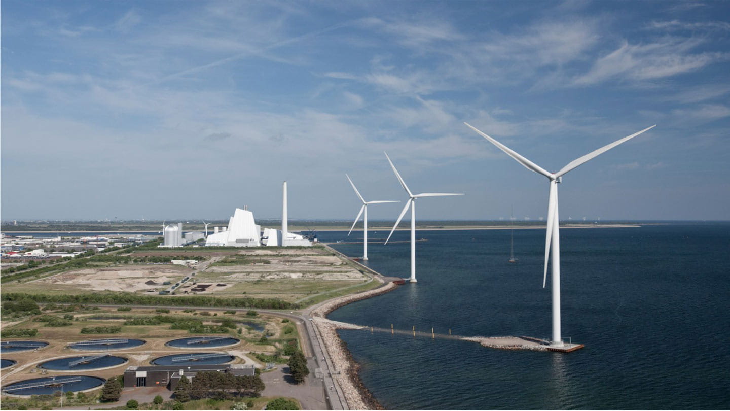 Three Ørsted wind turbines standing next to a renewable hydrogen power plant.