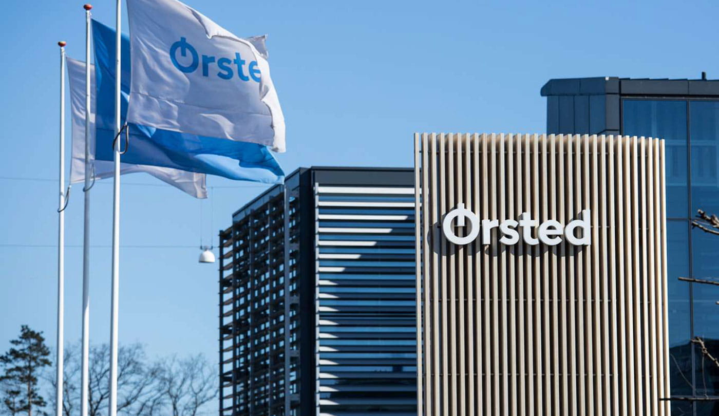 The Ørsted office surrounded by blue sky and waving Ørsted flags.