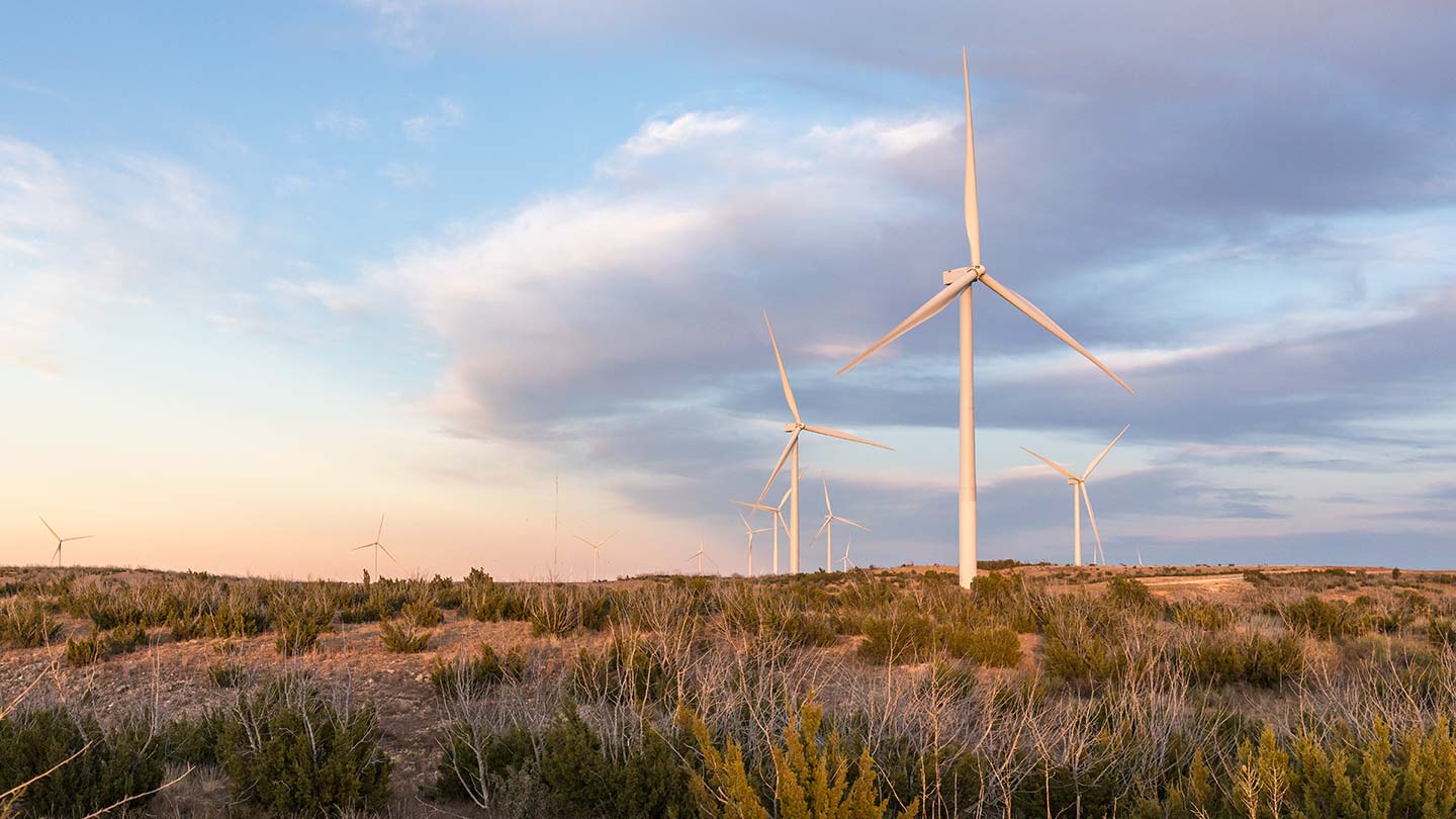 A group of onshore wind turbines in the desert.