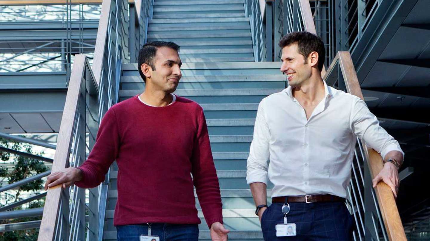 Two colleagues having a conversation on a staircase.