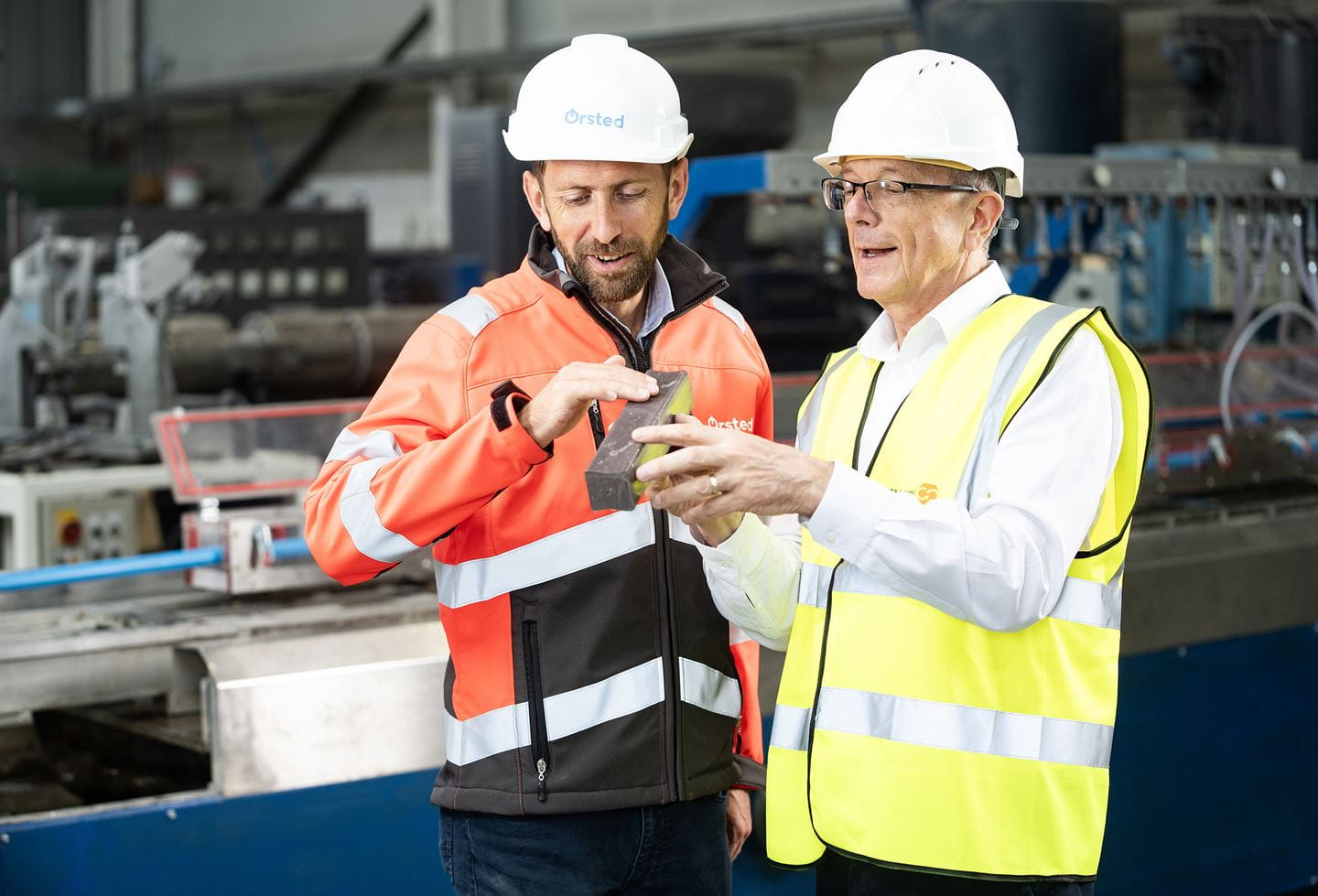 Two men holding a product created from a turbine blade