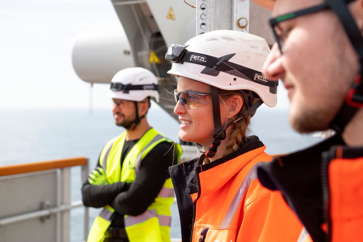 Three offshore wind technicians looking out to sea