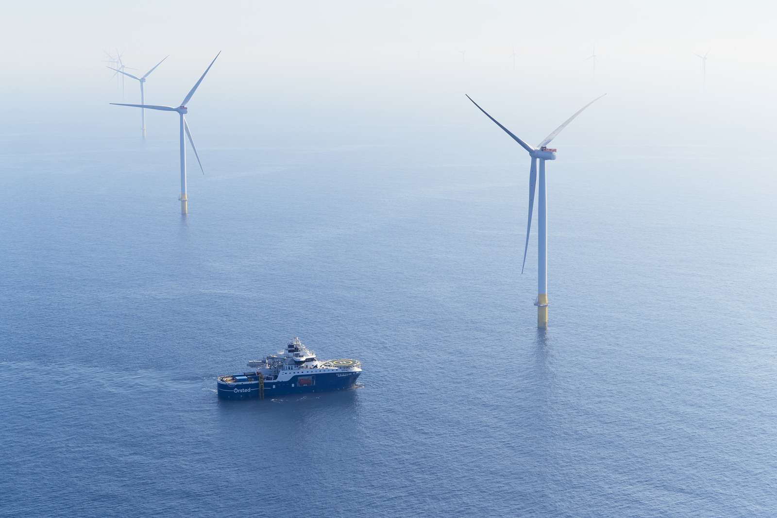 Image of vessel in foreground with offshore wind turbines in background