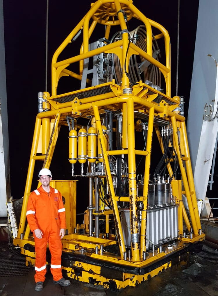 Technician standing in front of offshore wind equipment