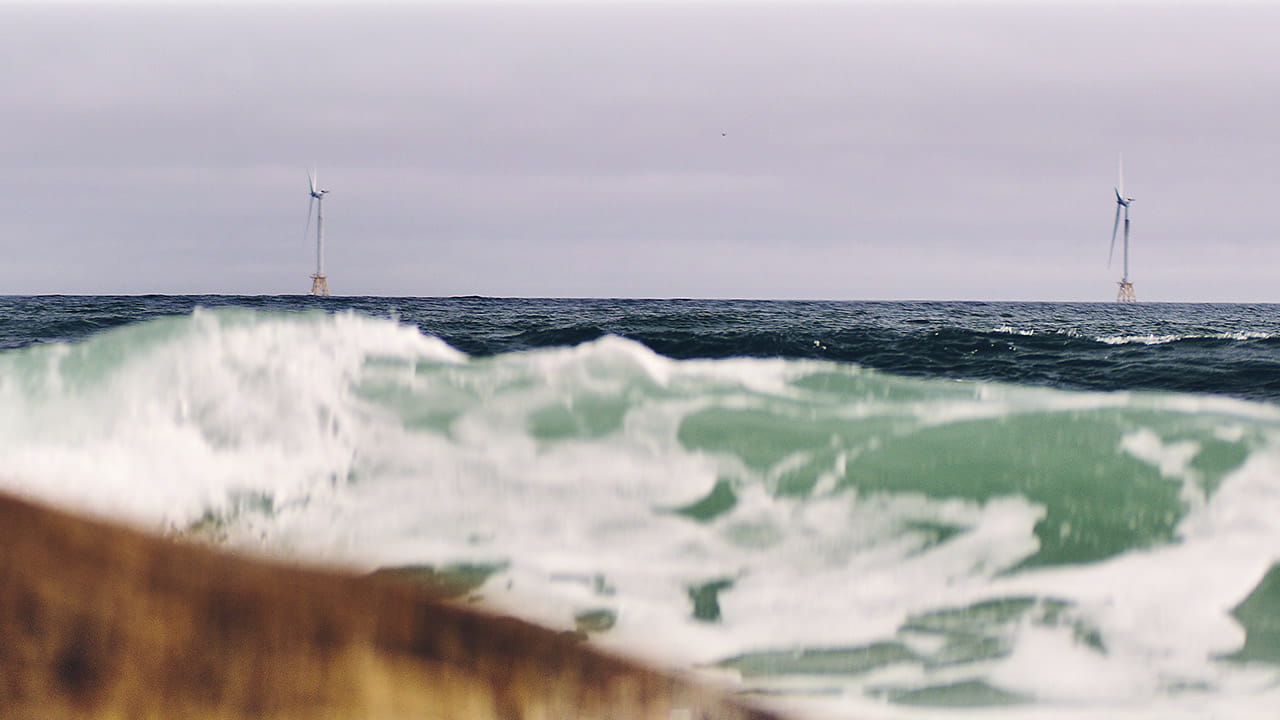 View from the beach of two of the five offshore wind turbines that make up Ørsted's Block Island Wind Farm.