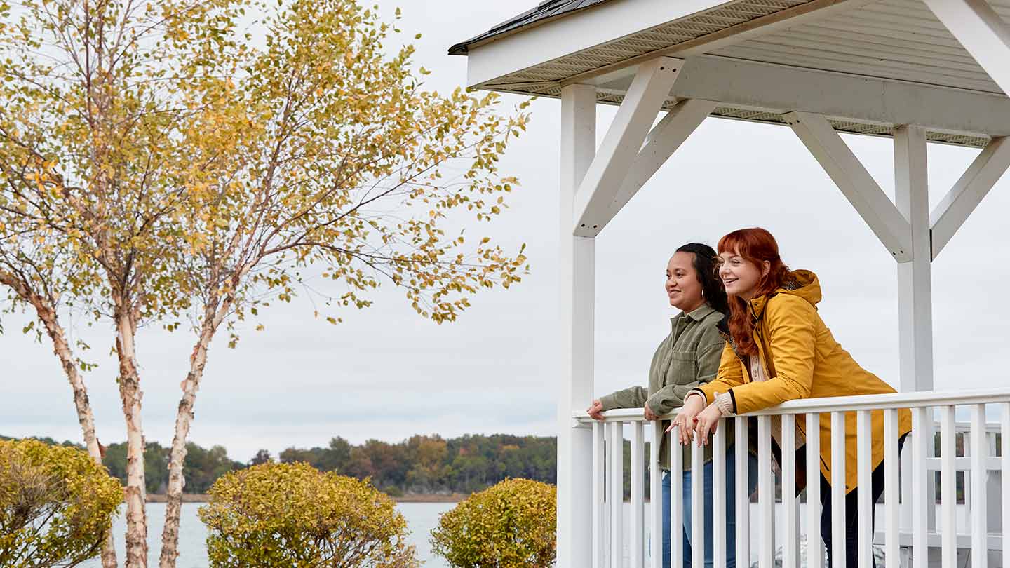 Two women on the porch of a university building, showing the kind of local community where Ørsted builds partnerships.