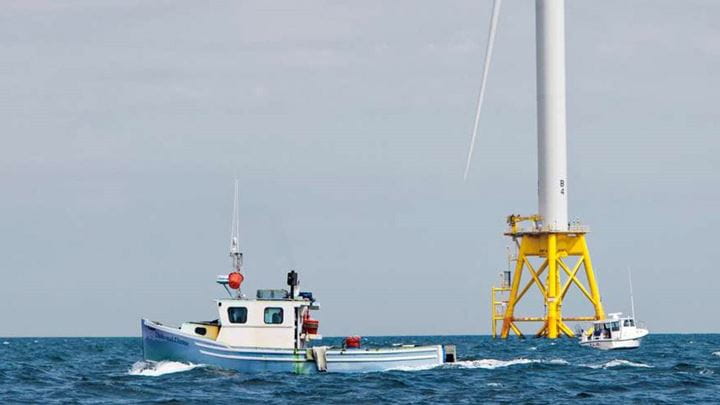 A fishing vessel navigating around an offshore wind turbine using information from Ørsted's East Coast Mariners Briefing.