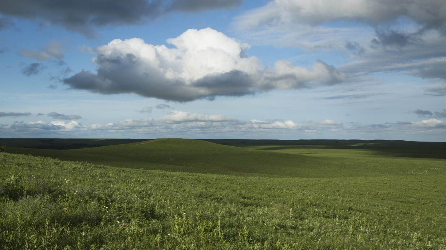 White and gray clouds hang over acres of native tallgrass prairies in Kansas being conserved by $2 million from Ørsted.