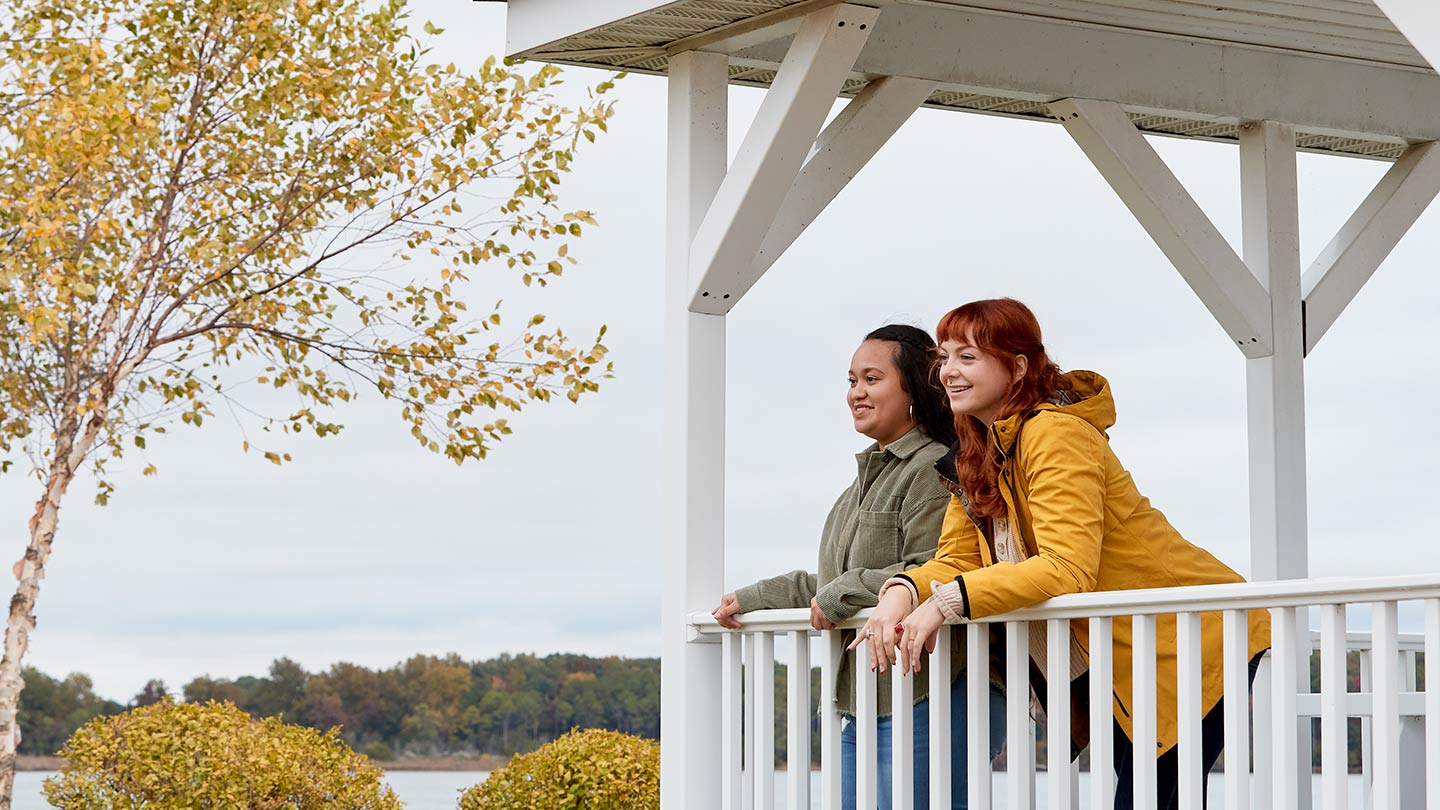 Two women on the porch of a university building, showing the kind of local community where Ørsted builds partnerships.