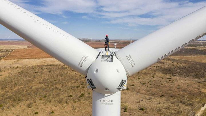An Ørsted technician standing on an onshore land turbine, which will provide clean energy for P2X projects like HyVelocity