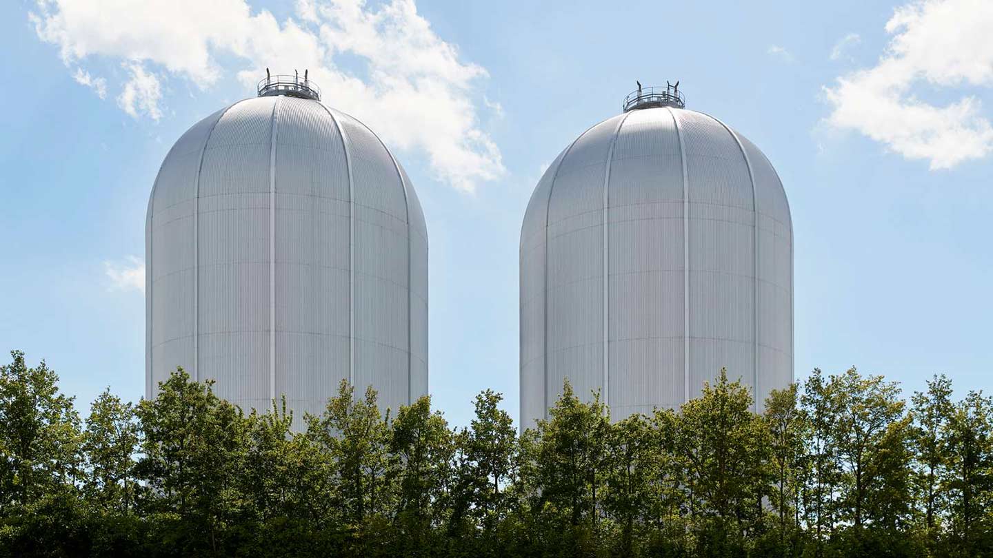 Two large gray tanks holding green hydrogen, one of Ørsted's renewable energy solutions for America.