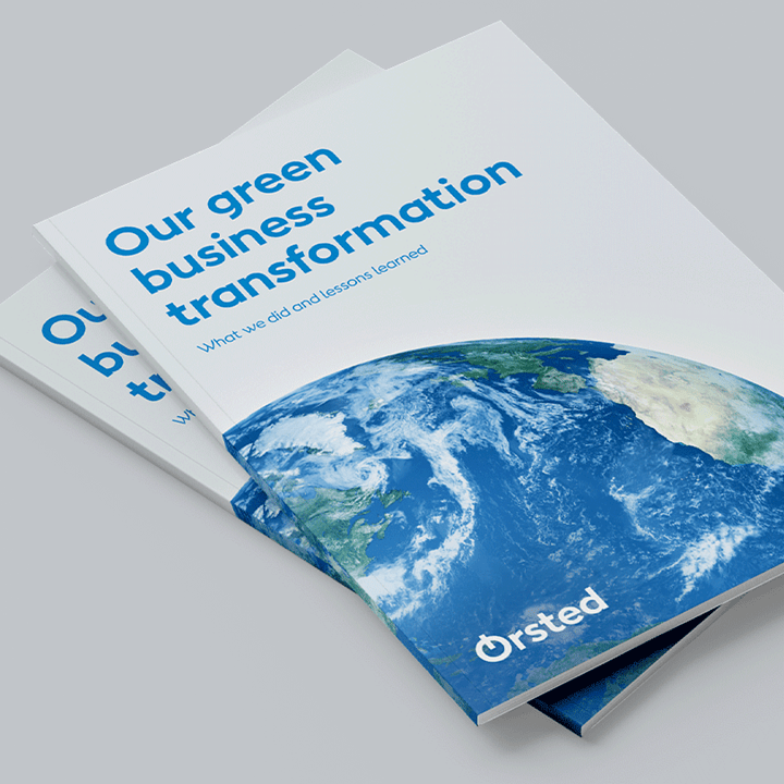Two booklets entitled 'Our green business transformation' sitting on a grey surface